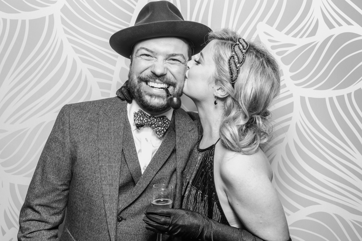 couple kissing during a birthday party entertainment photo booth hire cotswolds with black and white prints