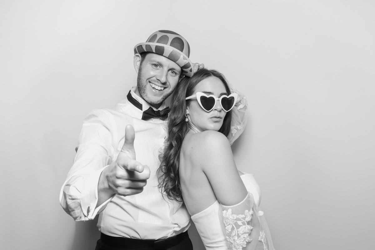 bride and groom posing for a black and white photo booth entertainment