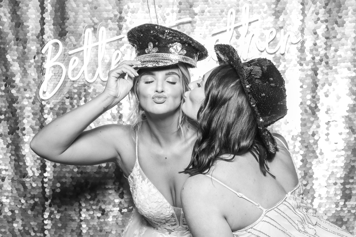 Kardashian style photo booth B&W with silver backdrop and neon sign