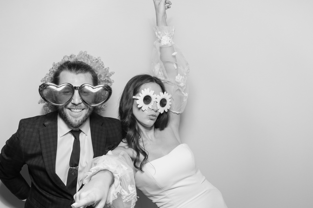 the bride and groom having fun and looking during the photo booth hire cotswolds