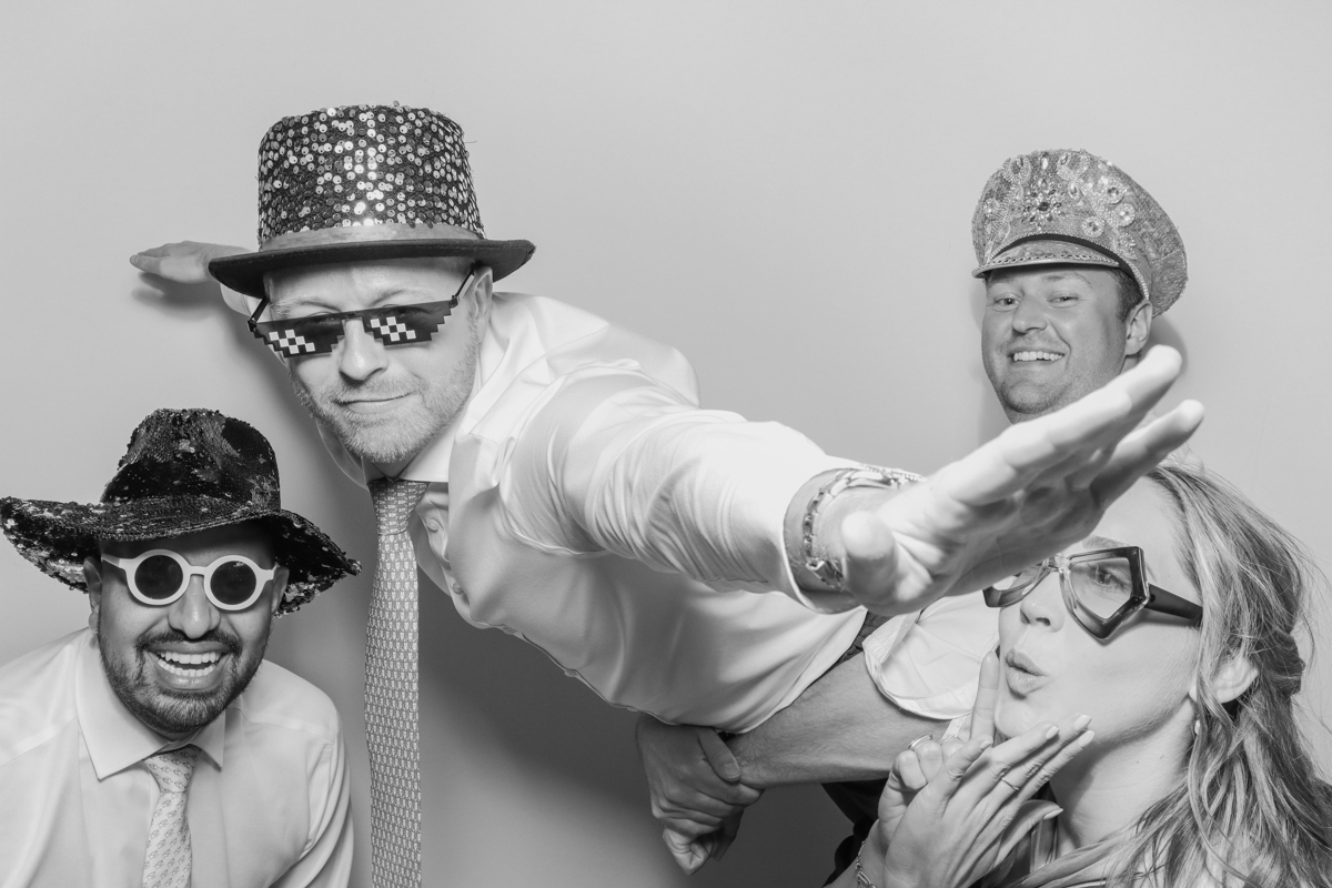 Four guests with various props and sunglasses, enjoying the photo booth, best wedding entertainment for a mickleton hills farm wedding venue in the Cotswolds