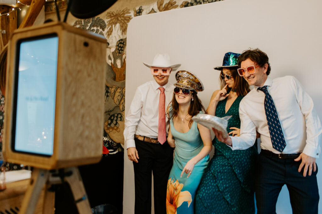 guests posing for the icon booth at owlpen manor wedding party entertainment, as the perfect fit in a barn  for a cotswolds wedding
