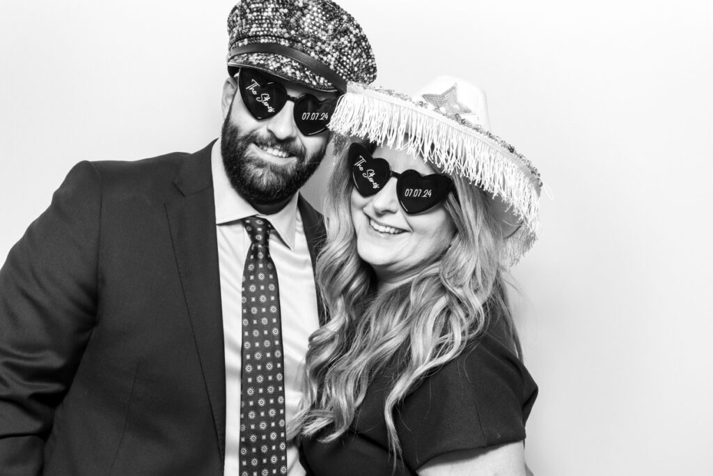 a couple wearing custom sunglasses during a Photo Booth Hire in Leicester  for a wedding party entertainment with a b&w filter