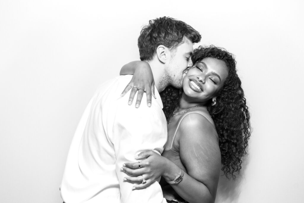 beautiful portrait of a couple where the man is kissing the girl on her cheek posing for a photo booth hire in leicester 