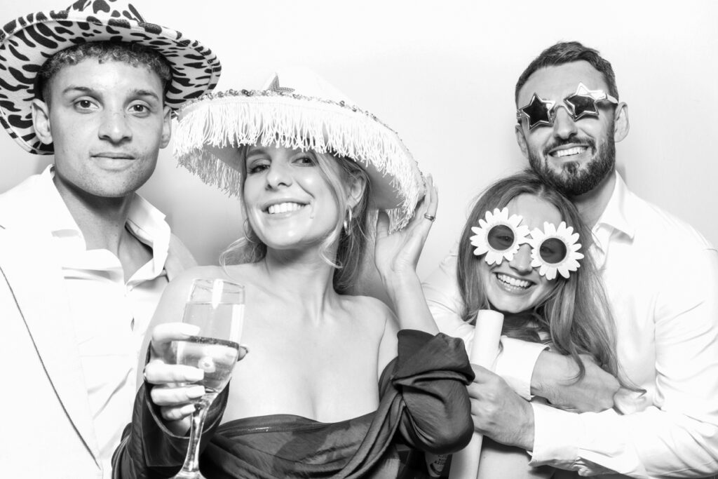 4 guests having fun during a Photo Booth Hire for a party entertainment with a b&w filter
