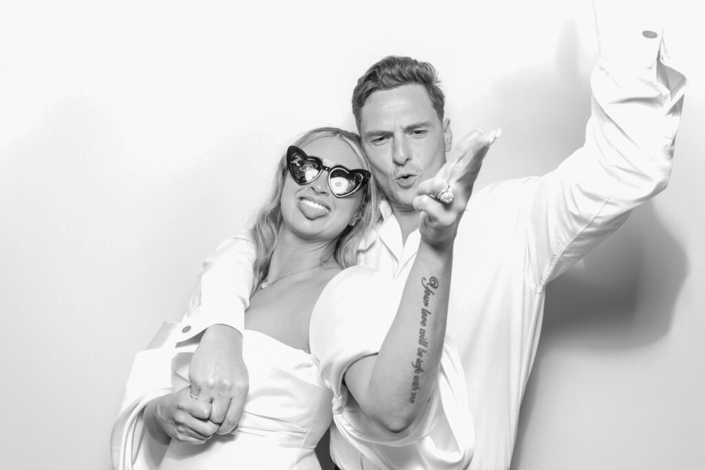 bride and groom having a fantastic time during a leicester party photo booth rental with the black and white filter
