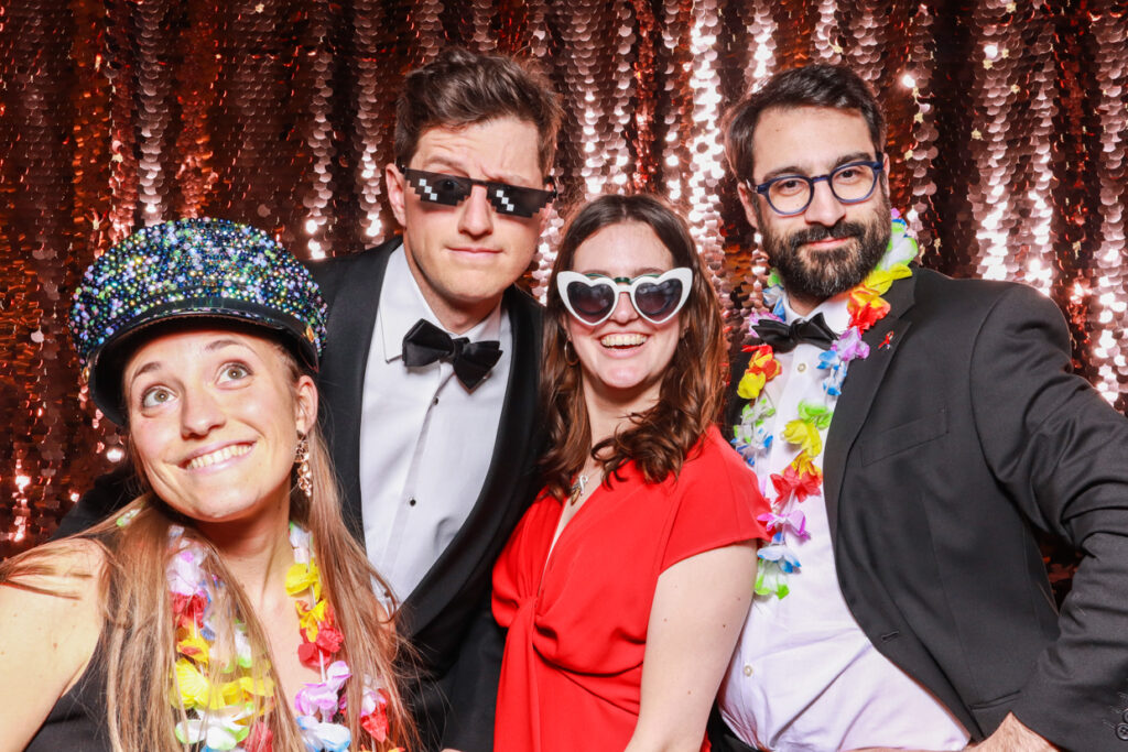 4 guests with fun props and heart shaped glasses during a photo booth hire party entertainment in cotswolds