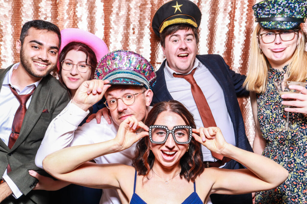 a large group of people with fun props and heart shaped glasses during a photo booth hire party entertainment in cotswolds 