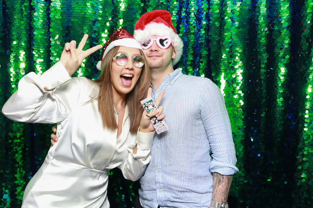 couple wearing festive props, during a christmas party photo booth