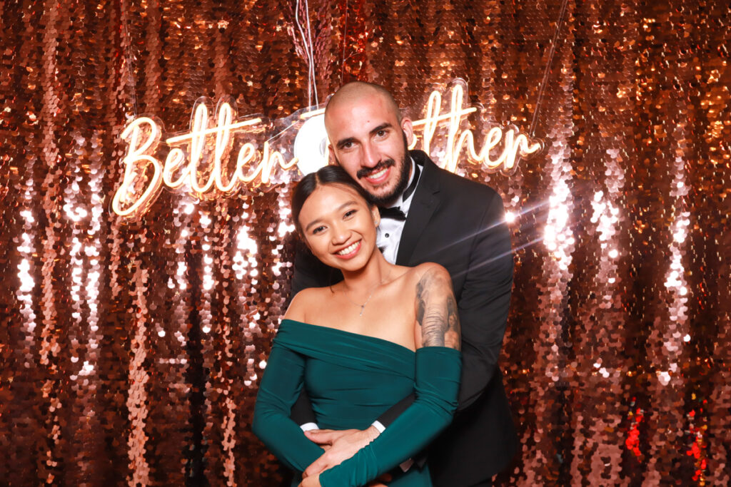 elegant couple posing hugging with a champagne backdrop during a Luxury photo booth rentals event for a corporate party