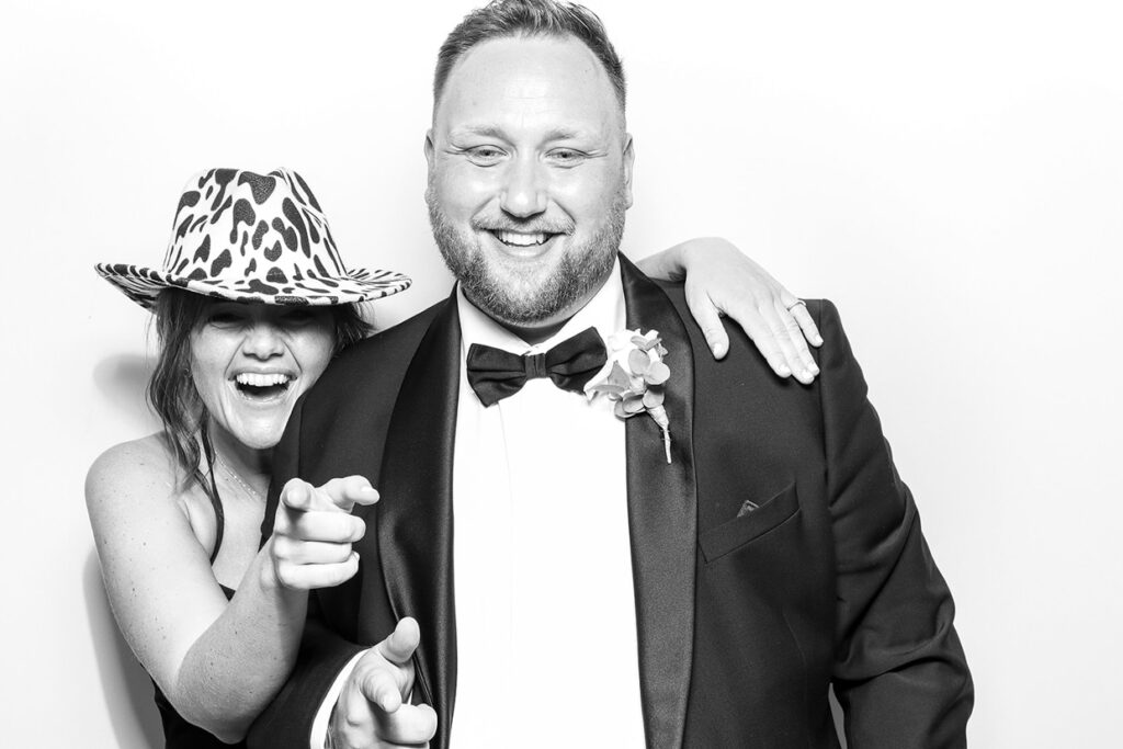 2 guests having lots of fun posing in a suit for a brand event with a kardashian glam photo booth b&w 