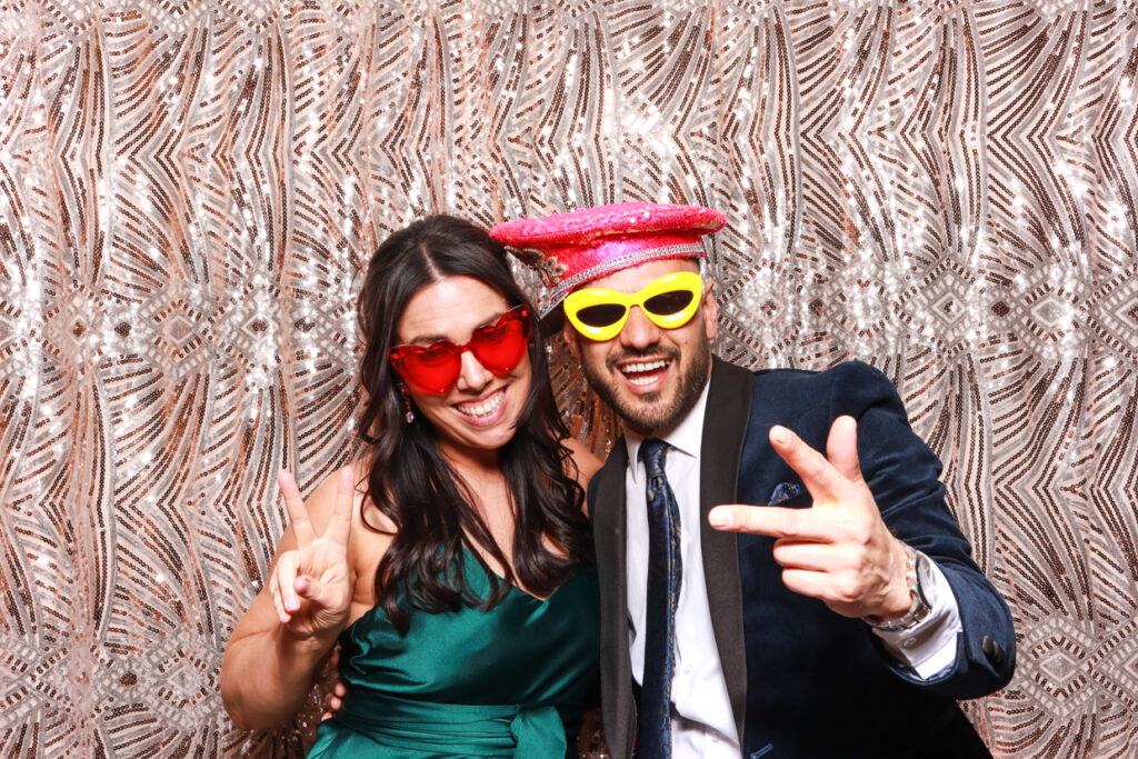 couple posing against a boho backdrop during a wedding party entertainment