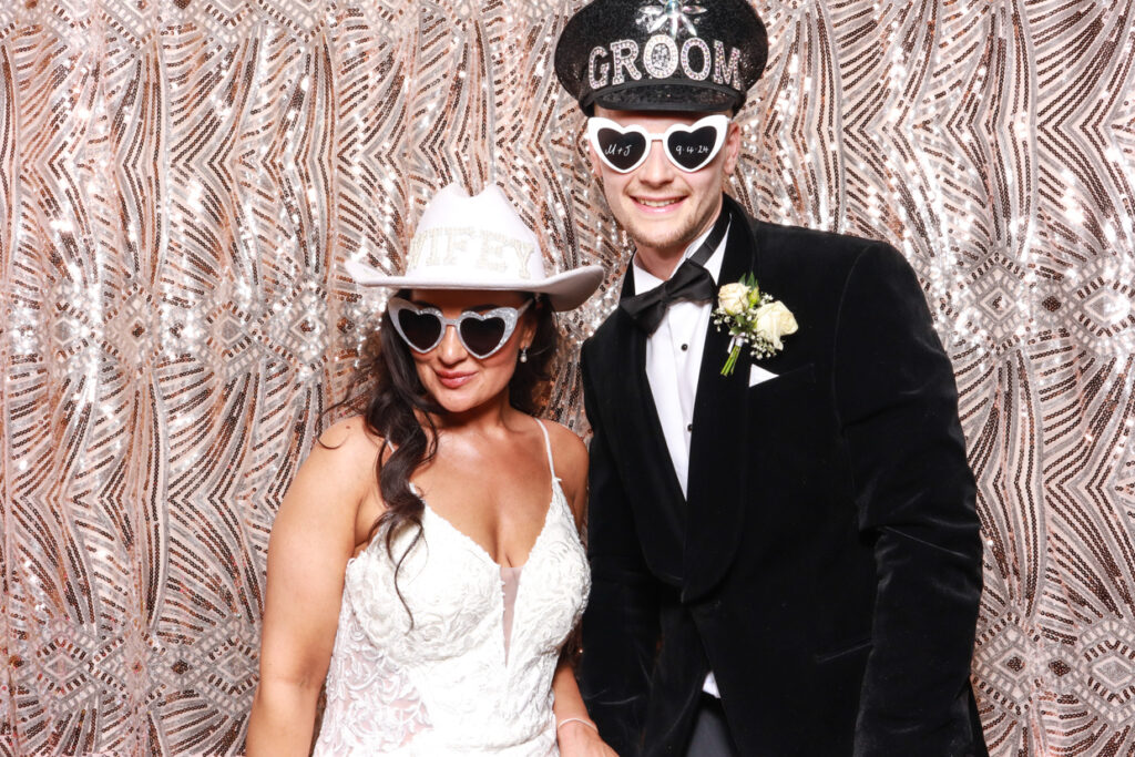 bride and groom posing against a boho backdrop during a wedding party entertainment