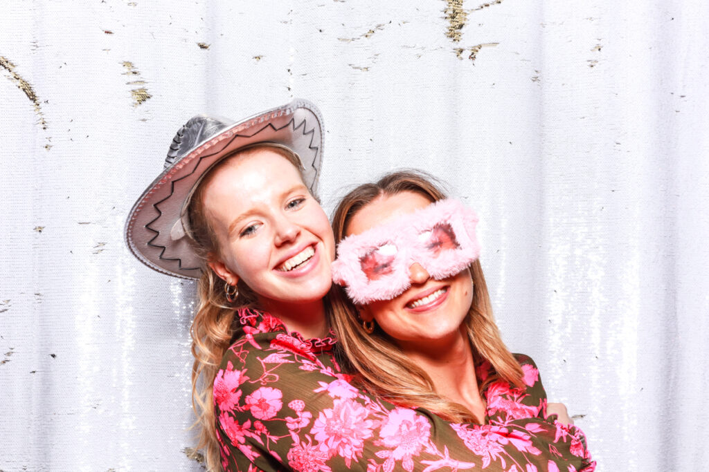 2 ladies posing against a white backdrop during a private party photo booth hire