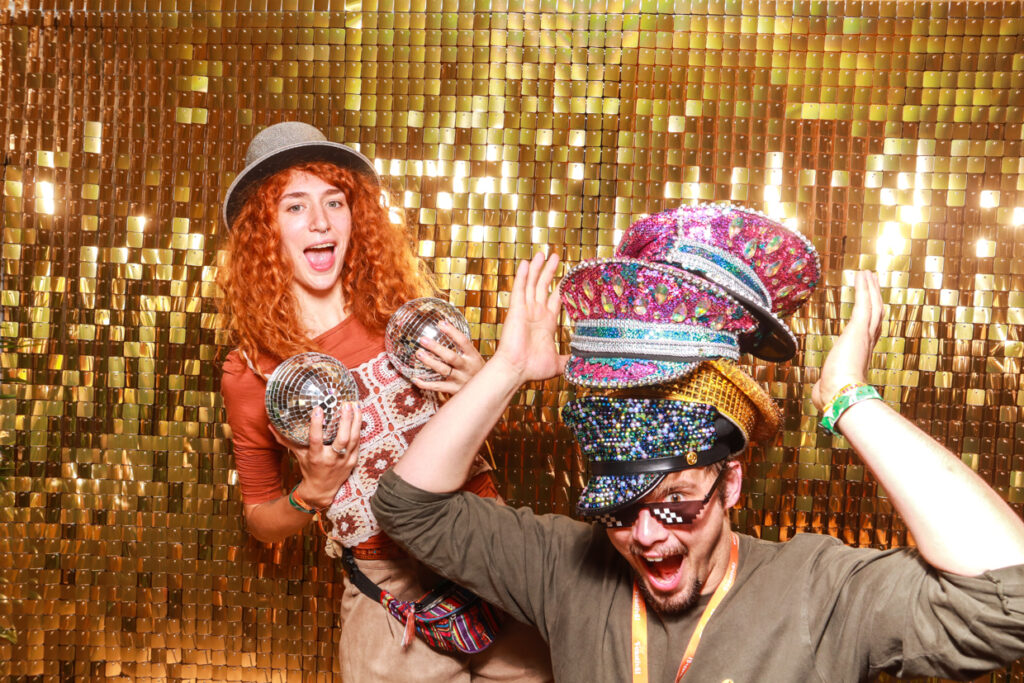 2 guests at a party wearing lots and lots of hats and props during a corporate event success party entertainment for the big feastival in the Cotswolds