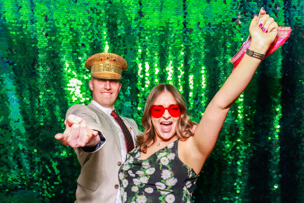 2 guests during a corporate event party entertainment, against a green sequins backdrop for a fantastic event entertainment