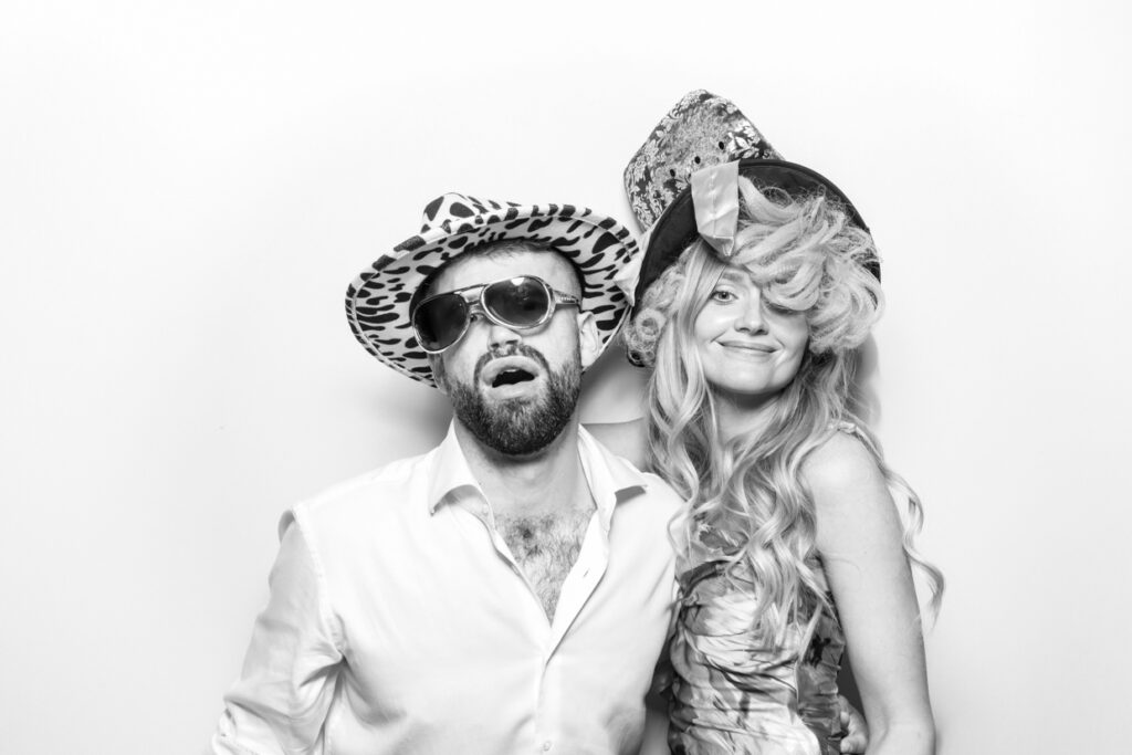 couple using fun props during a christmas party photo booth 