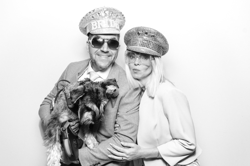 guests having fun holding a dog during a photo booth corporate party