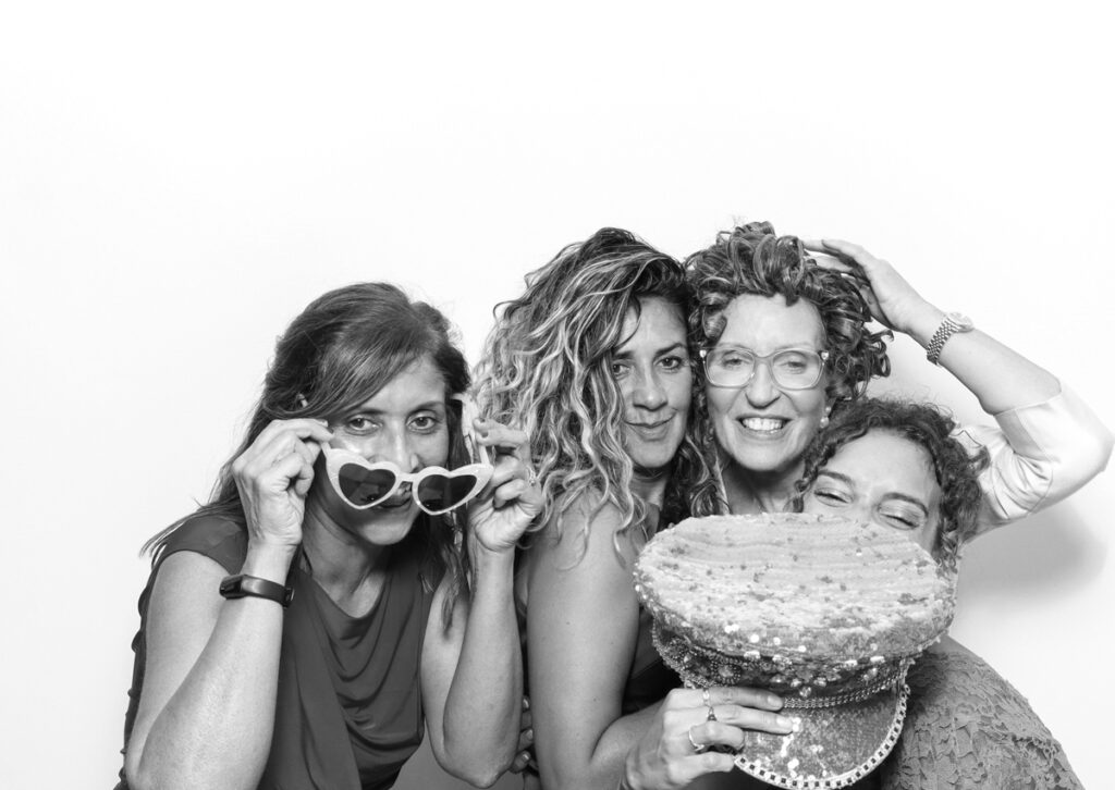 4 ladies posing against a white backdrop using mad hat photo booth hire cotswolds party entertainment 