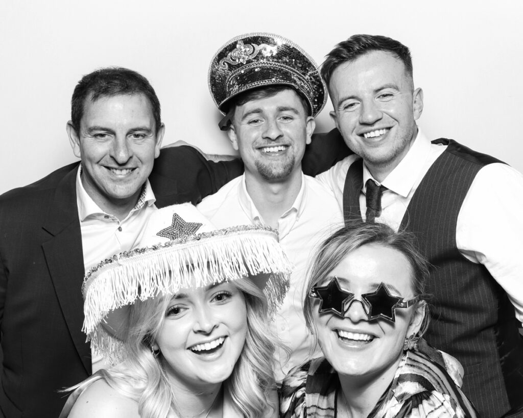 b&w photo of 5 guests posing and having fun with sequins hats and props at the The Great Barn Aynho Wedding Photo Booth with  mad hat photo booth rental Banbury