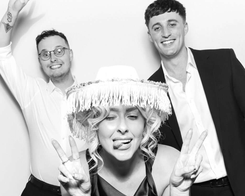 3 guests posing and having fun with hats during a wedding party entertainment with  mad hat photo booth rental in Banbury, Oxfordshire