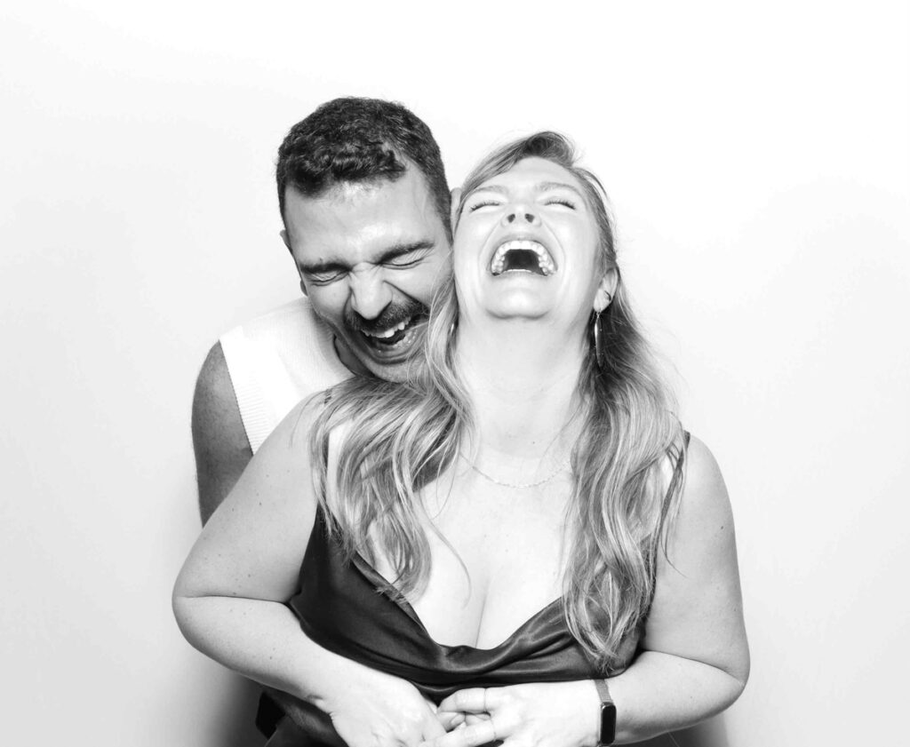 A couple striking a classic pose with playful expressions, showcasing a fun moment captured by the Cotswolds photo booth rental.