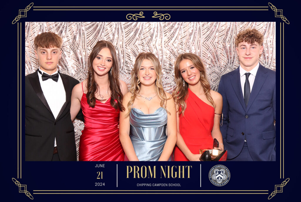 Group of five students dressed in formal attire posing at Chipping Campden School Prom Night 2024, with a stylish gold and white patterned backdrop and elegant event branding