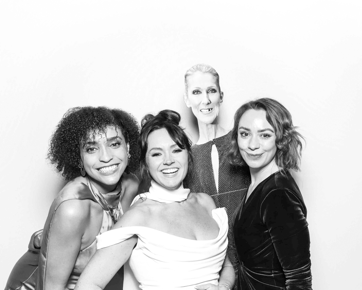 Group of women posing playfully in a black and white photo booth session with a celebrity cut-out, during a wedding or professional event in Oxfordshire.