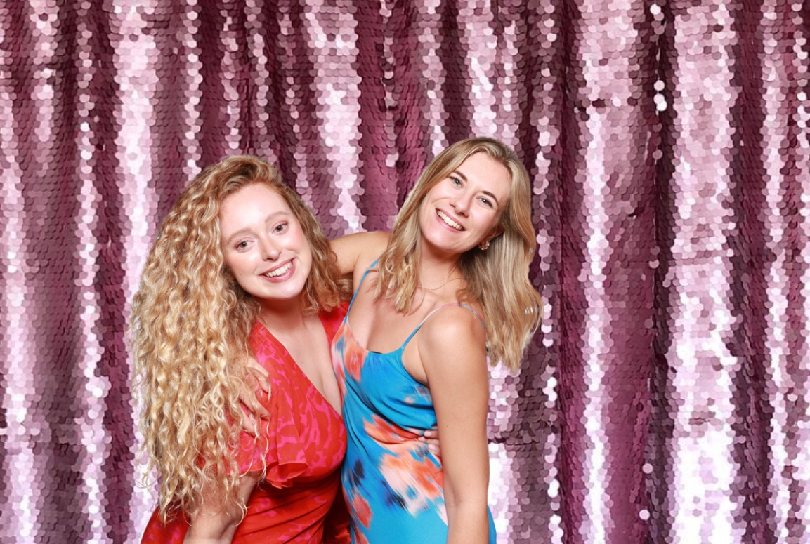 2 friends posing against a lilac sequins backdrop, during a valentines day photo booth event, the perfect entertainment for shopping malls