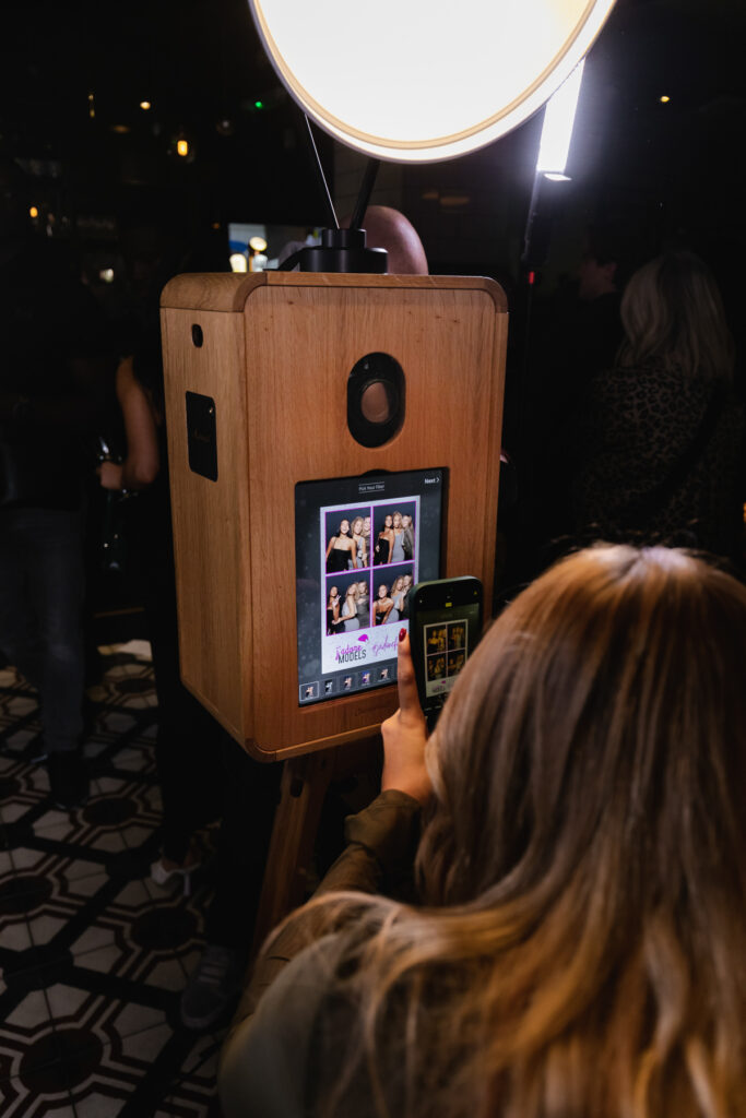 modern icon photo booth during a corporate party entertainment, mad hat photo booth rental 