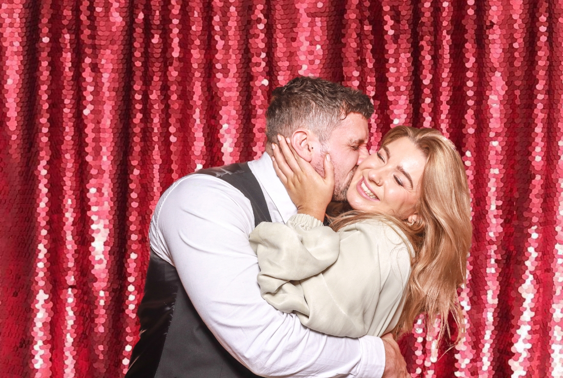 couple kissing against a lilac sequins backdrop during photo booth event, the perfect entertainment for shopping malls and restaurants