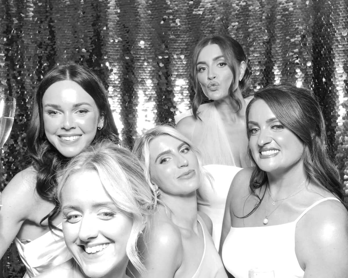 group of guests posing against a sequins backdrop during a wedding party photo booth rental for oxfordshire