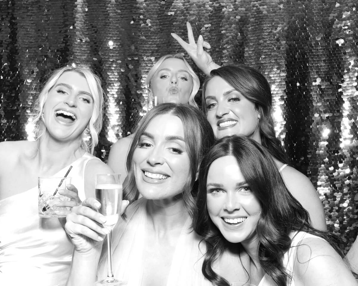 bridesmaids and bride with silver backdrop during a wedding party entertainment 