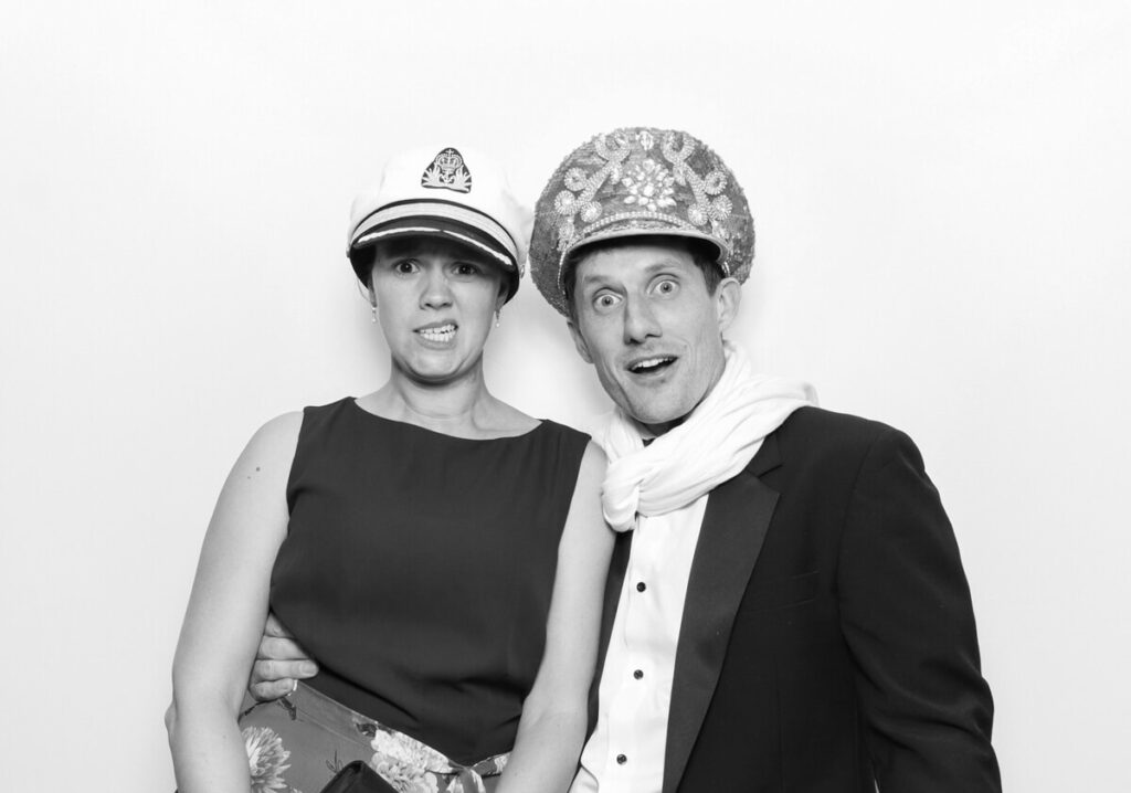 funny image of couple posing against a white backdrop for the party entertainment during the reception for a luxury venue