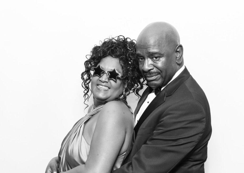 portrait of couple posing against a white backdrop for the party entertainment during the reception for a luxury venue