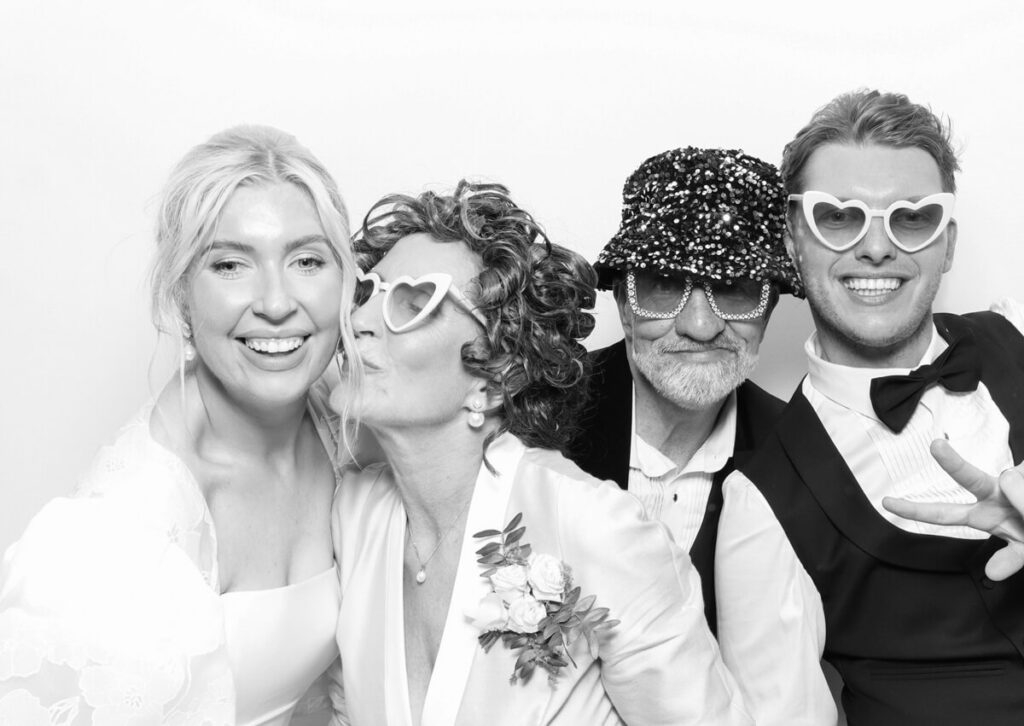 guests posing for a luxury photo booth hire at Kin house standing  against a white backdrop with a kardashian style photo booth print