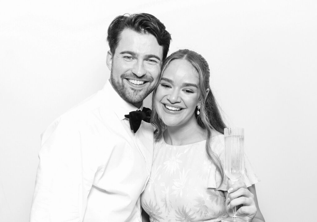 b&w print of a couple posing against a white backdrop for the party entertainment during the reception for kin house luxury venue