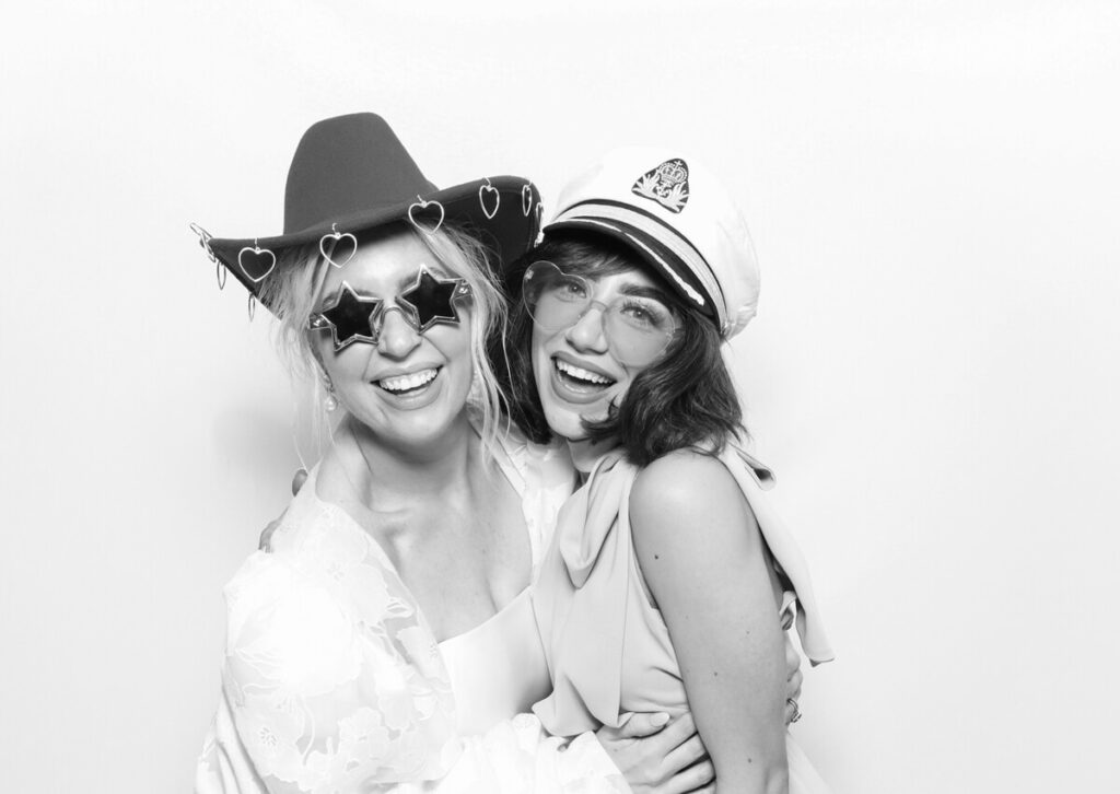 b&w print of 2 girls posing against a white backdrop for the party entertainment during the reception for a luxury venue