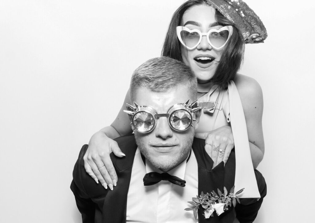 black and white image with the kardashian filter on of  a couple wearing fun props during a private party event entertainment in the Cotswolds