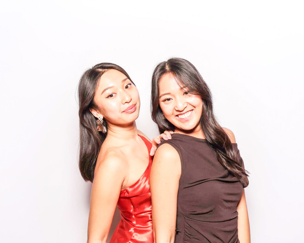 2 girls posing against a white backdrop, for a photo booth hire in the cotswolds or oxfordshire