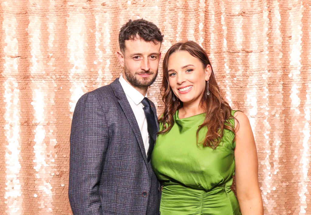 2 guests posing against a blush sequins backdrop, for a selfie pod private party hire in Cotswolds area
