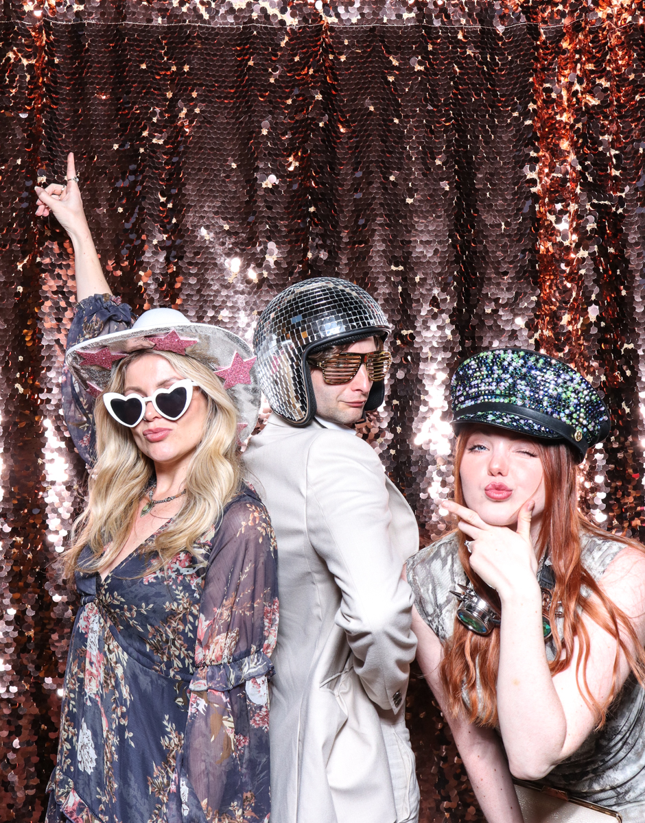 3 guests posing with super fun props, against a champagne sequins backdrop, for a cripps barn cotswolds wedding party entertainment with mad hat photo booth hire for parties, birthdays and weddings