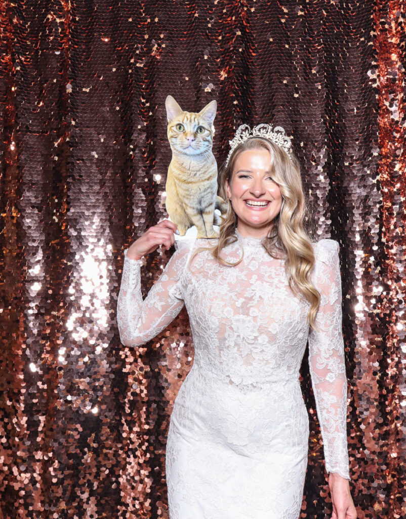 bride posing with a cat cut out, during a wedding party entertainment in the cotswolds