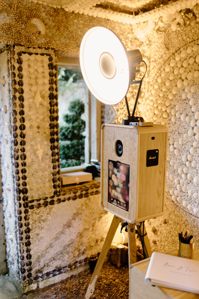 Close-up of Mad Hat’s Icon photo booth inside Belcombe Court’s unique shell grotto, with decorative details surrounding the setup.