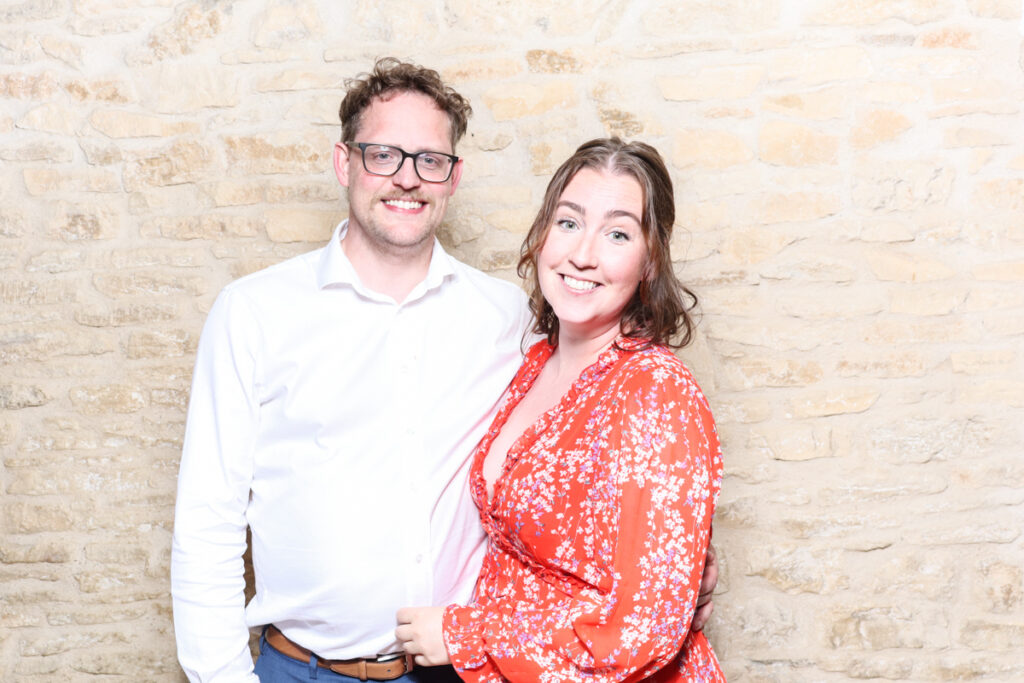 Couple smiling brightly in a casual iPad photo booth party entertainment