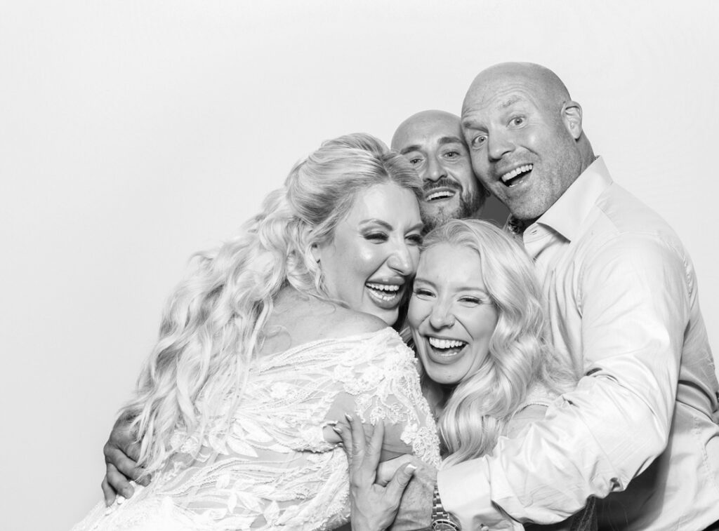 bride and guests hugging during a wedding event for the armada house photo booth with b&w filter during the best party entertainment in Bristol