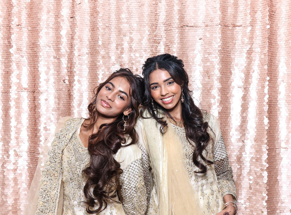 Guests enjoying the luxury Asian weddings photo booth with blush sequin backdrop by Mad Hat Photo booth at Farleigh House wedding venue