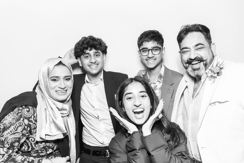 Family laughing together inside a modern photo booth at a luxury wedding celebration with a clean Kardashian finish