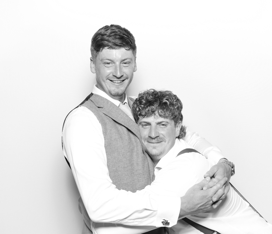 B&W image of guests posing for a premium photo booth rental at Ivy Lodge wedding venue Cirencester
