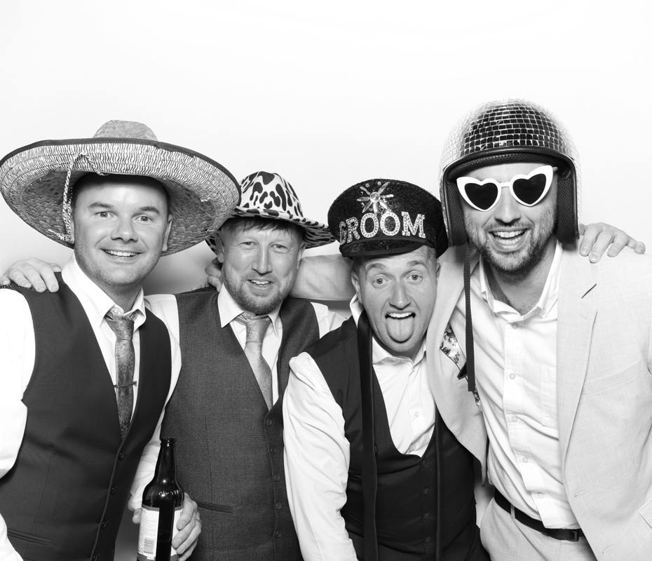 4 guests wearing hats and sunglasses posing for a B&W kardashian style photo booth at Ivy Lodge in Cirencester

